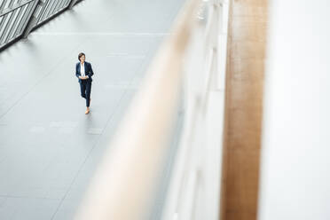 Weibliche Unternehmerin geht im Korridor im Büro - JOSEF03792