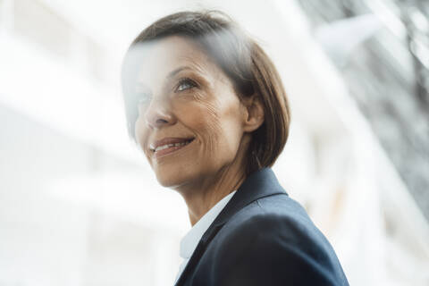 Thoughtful businesswoman looking away in office stock photo