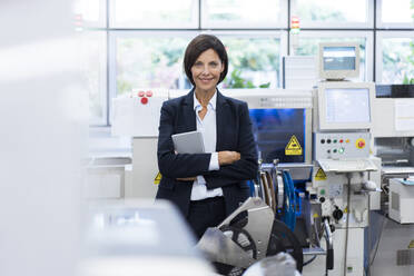 Confident businesswoman with arms crossed in factory - JOSEF03860