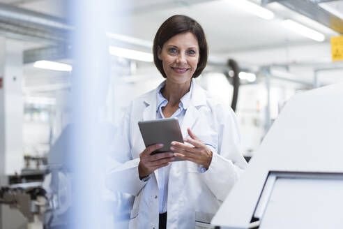Smiling female scientist with digital tablet at laboratory - JOSEF03862