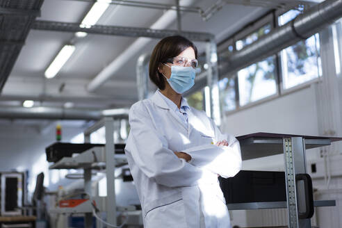 Female scientist with arms crossed in laboratory during pandemic - JOSEF03867