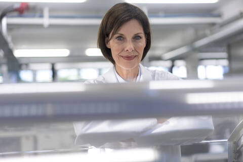 Female scientist by machinery in industry stock photo