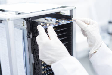 Female technician inserting circuit board in machinery at industry - JOSEF03891