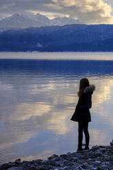 Deutschland, Bayern, Junge Frau mit Blick auf den Walchensee bei Sonnenuntergang - LBF03396