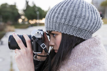 Teenage girl photographing through camera outdoors - JRVF00285