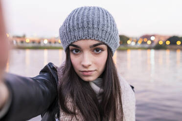 Teenager-Mädchen nimmt Selfie gegen Fluss bei Sonnenuntergang - JRVF00288