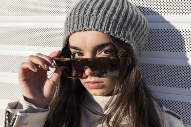 Teenager girl in sunglasses against white wall - JRVF00299