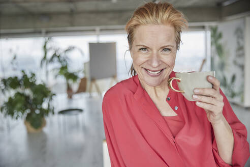 Beautiful mature woman with coffee cup at home - FMKF07044