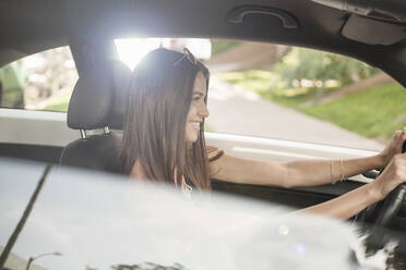 Smiling happy woman driving car - AJOF01122