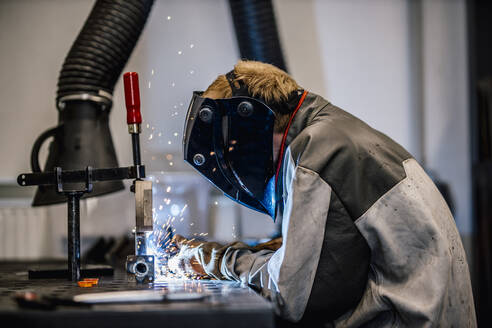 Welder with coveralls working at factory - DAWF01830