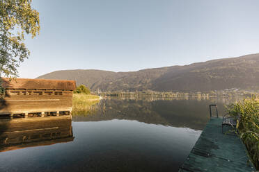 Spiegelung eines Berges im Wasser bei Sonnenaufgang, Ossiacher See, Österreich - DAWF01838