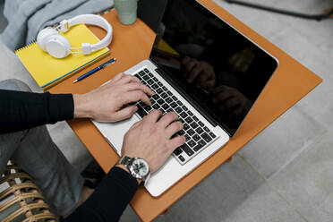 Geschäftsmann mit Laptop auf dem Tisch, während er im Café sitzt - EGAF01915