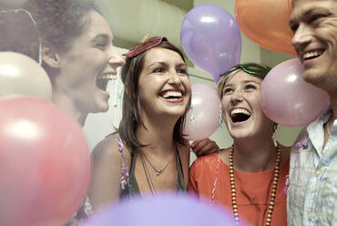 Lächelnde Freunde, die auf einer Party zusammen stehen - AJOF01131