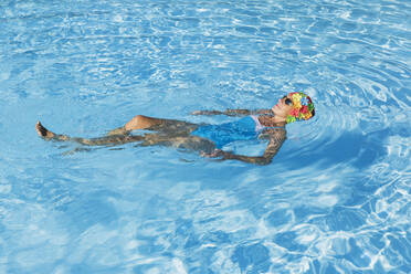Frau entspannt sich im klaren blauen Schwimmbad - GWF06907