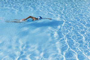Frau schwimmt im klaren blauen Schwimmbad - GWF06909