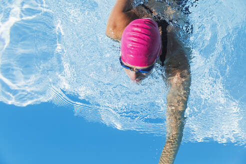 Woman swimming in clear blue swimming pool - GWF06911