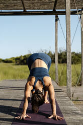 Woman practicing yoga in gazebo - AMPF00054