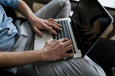 Businessman working on laptop while sitting at home - EGAF01933