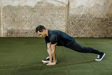 Mann bei Übungen an der Wand im Fitnessstudio - KVF00155