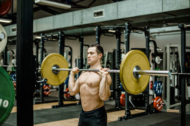 Hemdloser männlicher Athlet beim Gewichtheben im Fitnessstudio - KVF00182