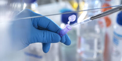 Männlicher Wissenschaftler, der eine chemische Formel in ein Fläschchen im Labor pipettiert - ABRF00844