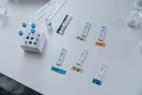 Variation von Schnelldiagnosetestkassetten mit Zeitaufkleber auf dem Tisch in der Klinik - MFF07472