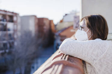 Thoughtful woman in balcony during pandemic - EBBF02596