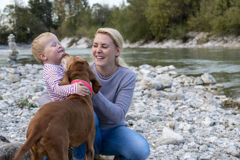Junge Mutter mit ihrem Sohn und Hund beim Spielen am Flussufer - LBF03411