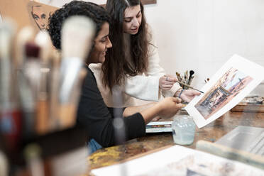 Junge Malerinnen diskutieren in einem Atelier über Malerei - JCCMF01309