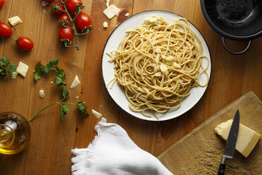 Mit Spaghetti gefüllter Teller auf Holztisch - IFRF00419