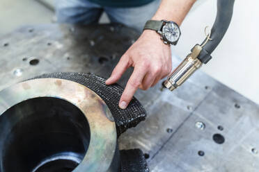 Männlicher Ingenieur bei der Arbeit mit einem automatischen Schweißbrenner an einer Anlage in einer Fabrik - DIGF14666