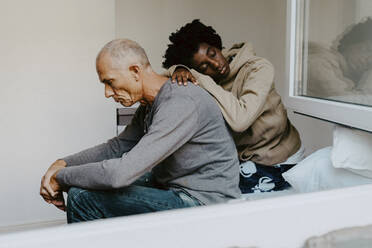 Stressed father and daughter sitting in bedroom - MASF21922