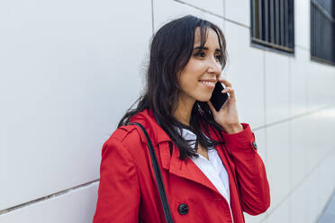 Junge Frau schaut weg, während sie telefoniert - JRVF00325