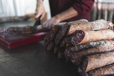 Butcher cutting pork meat in slaughterhouse - JAQF00314