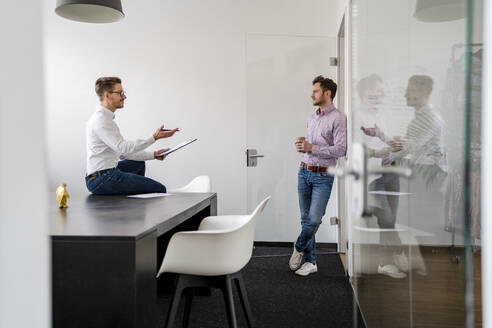 Männliche Unternehmer diskutieren bei einer Besprechung im Büro - DIGF14688