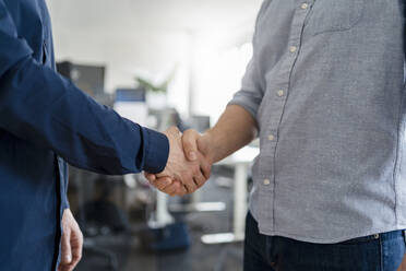 Male entrepreneurs shaking hands at office - DIGF14749