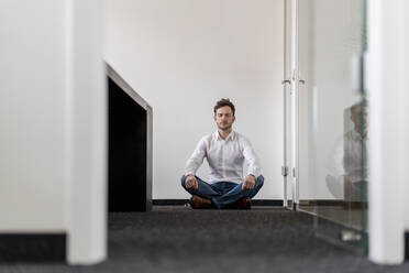 Geschäftsmann meditiert Yoga im Büro - DIGF14788