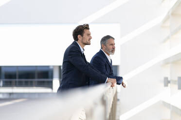 Entrepreneurs looking away while standing at office building terrace - SBOF02874