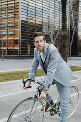 Geschäftsmann mit Fahrrad auf dem Fußweg in der Stadt stehend - GMCF00021