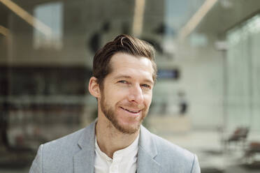 Smiling handsome male professional with brown hair and beard - GMCF00055