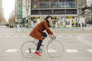 Mittlerer Erwachsener männlicher Hipster fährt Fahrrad in der Stadt - GMCF00065