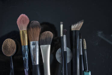 Make-up brushes on black table - RDGF00323