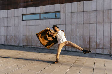 Männlicher Tänzer genießt den Tanz beim Üben gegen ein Gebäude - TCEF01631