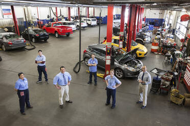 Porträt von sechs Mechanikern in einer Autowerkstatt von oben gesehen - MINF15833