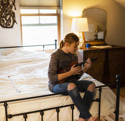 Teenager-Mädchen spielt Geige in ihrem Schlafzimmer - MINF15843
