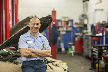 Porträt eines Automechanikers aus dem pazifischen Raum in einer Autowerkstatt - MINF15866