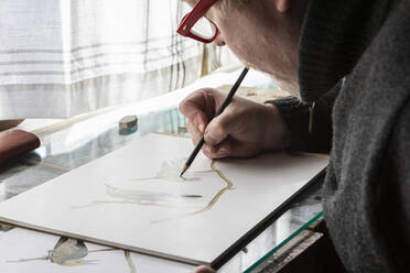 Reife Künstlerin bei der Arbeit, Zeichnung auf Papier, eine Studie über Vögel in der freien Natur. - MINF15908