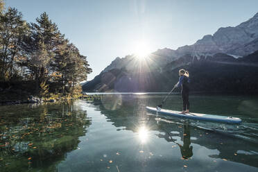 Deutschland, Bayern, Garmisch Partenkirchen, Junge Frau beim Stand Up Paddling auf dem Eibsee - WFF00471