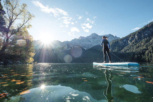 Deutschland, Bayern, Garmisch Partenkirchen, Junge Frau beim Stand Up Paddling auf dem Eibsee - WFF00476