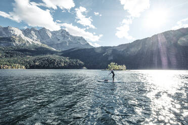 Germany, Bavaria, Garmisch Partenkirchen, Young woman stand up paddling on Lake Eibsee - WFF00486